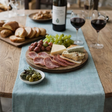 Ocean Mint Linen Table Runner dining table setting with food and tableware.