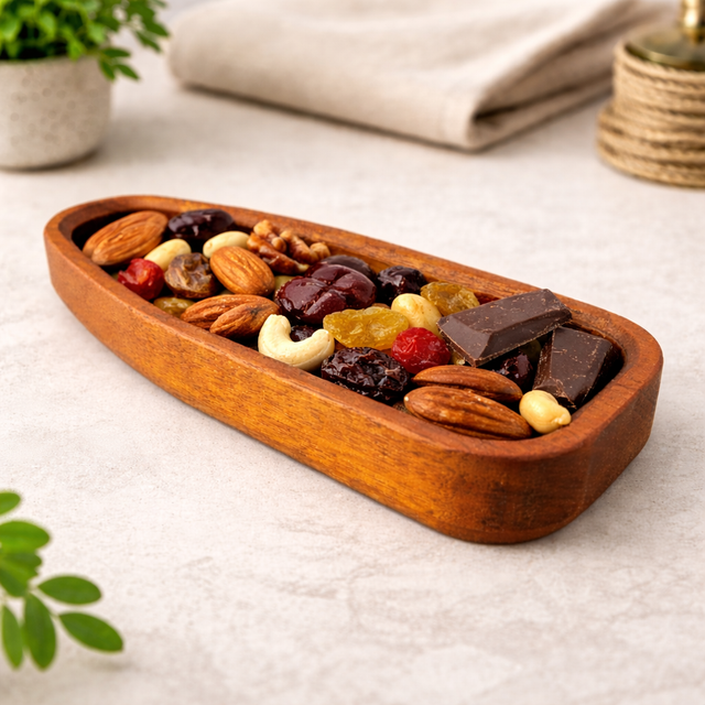 Wooden tray with assorted nuts and dried fruits on a light surface.