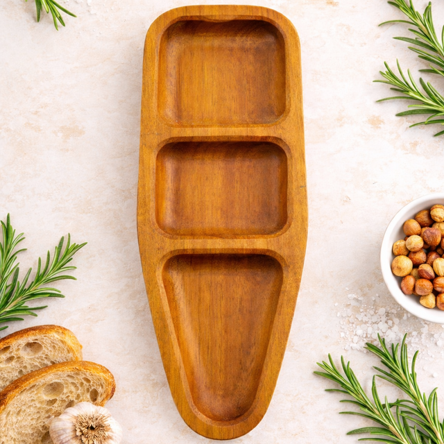 Wooden tray with compartments on a light surface with rosemary and bread slices.