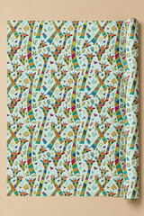 A roll of wrapping paper with a colorful repeating Patchwork Giraffe pattern on a light blue background, displayed against a solid beige backdrop.