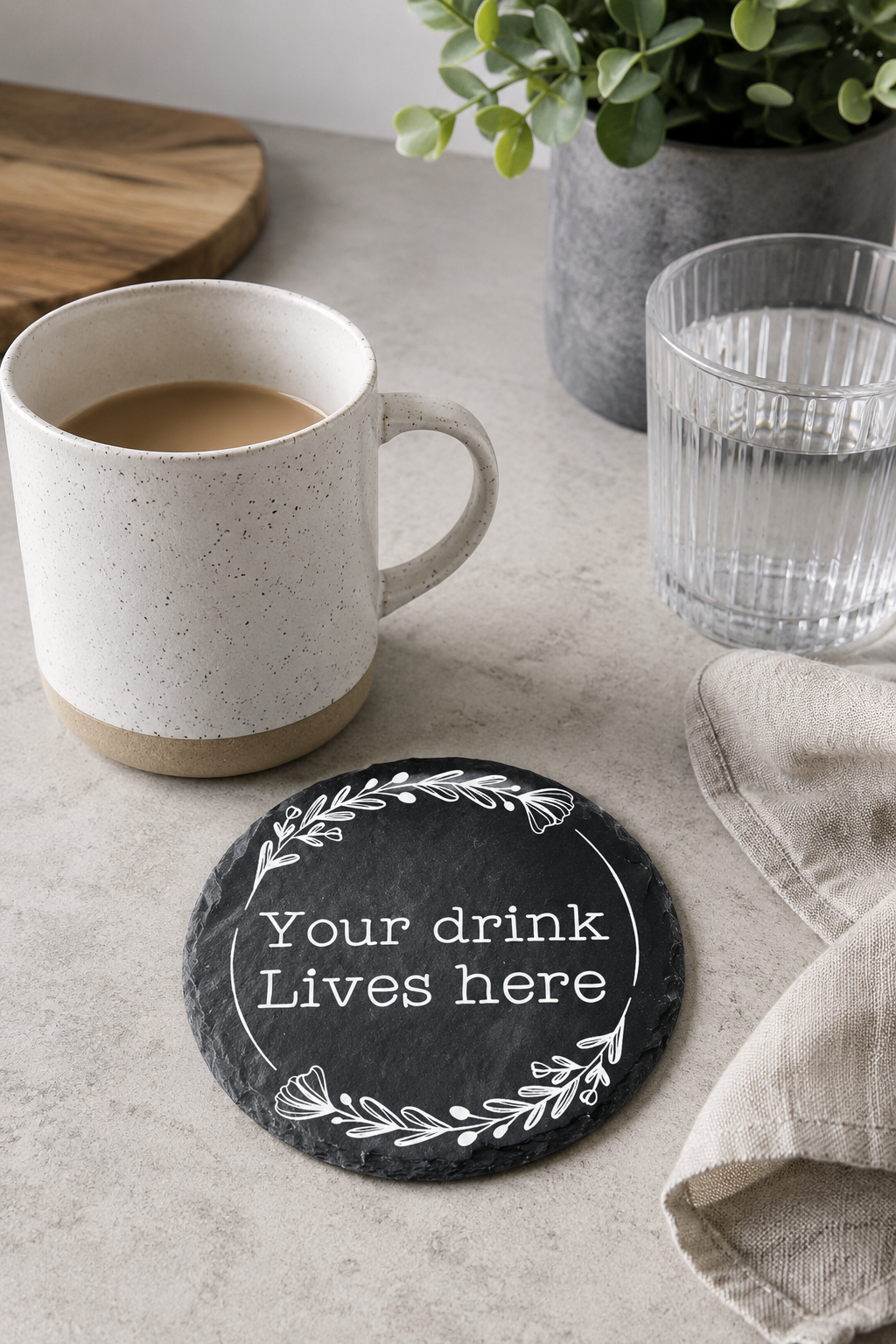 Personalised round slate drinks coaster engraved with wording, made from natural slate with rustic edges.