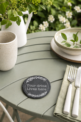Personalised round slate drinks coaster engraved with wording, made from natural slate with rustic edges.