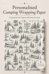 Personalised camping wrapping paper shown on a journal cover, featuring a black and white illustrated pattern of tents, campfires, canoes, mountains, and directional signs. Text at the top reads 'Personalised Camping Wrapping Paper' and a badge says 'Choose your own wording'.