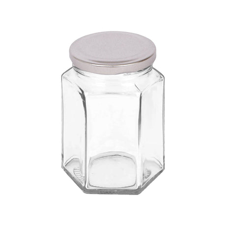 Hexagonal glass jar with a silver lid on a white background