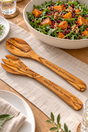 Personalised 30cm olive wood salad servers on oatmeal linen beside a large bowl of rocket, roasted squash, walnuts and pomegranate.