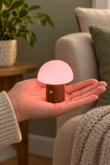 Super Mini Alice Mushroom Lamp in Walnut with pink illumination, resting in an open palm to show its small size