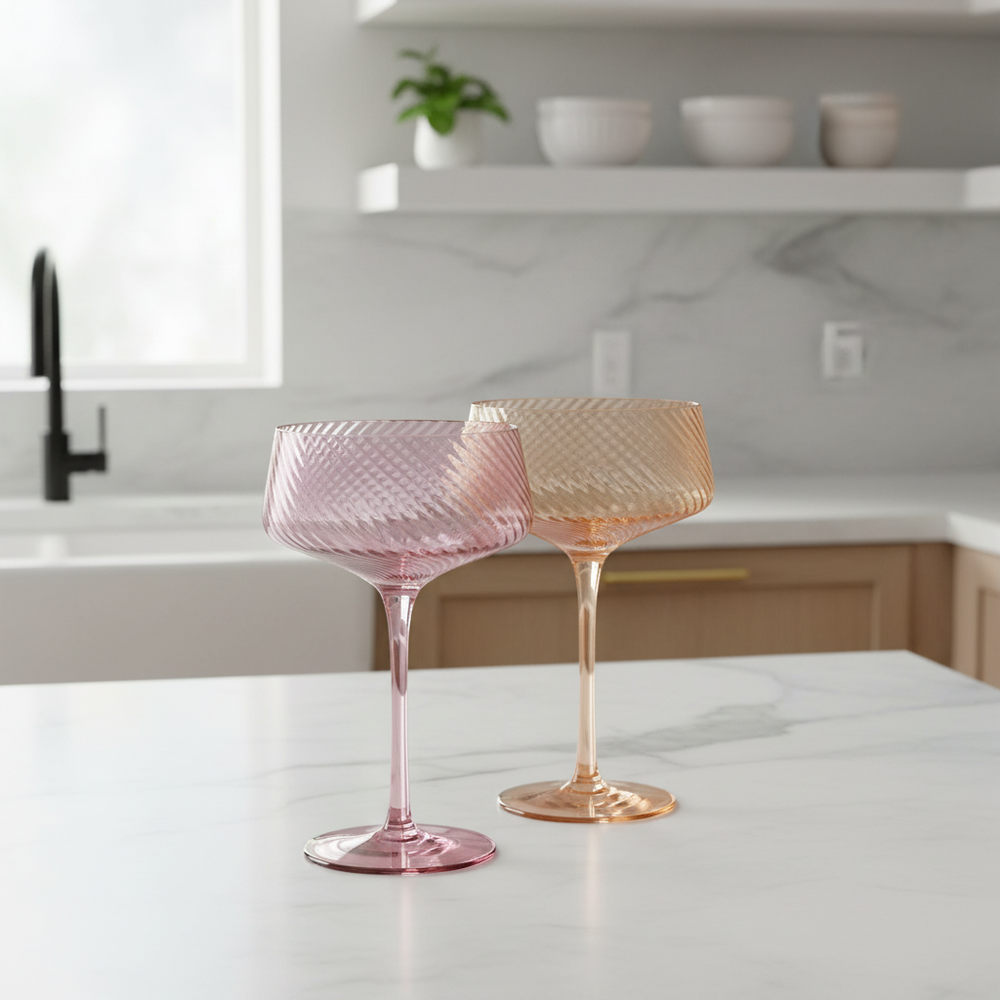 Two pink glass goblets on a white background