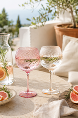 Pink and Peach twisted gin - wine glasses on a table with outdoor setting