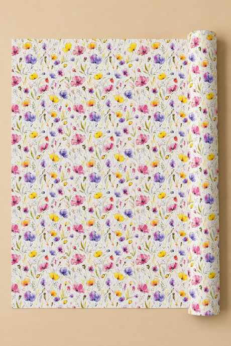 A roll of wrapping paper with a dense, colorful watercolor floral pattern on a white background, partially unrolled and displayed against a solid beige background.