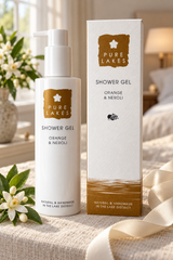 Pure Lakes Shower Gel bottle and matching box displayed on a beige fabric surface with white flowers and a soft indoor background.