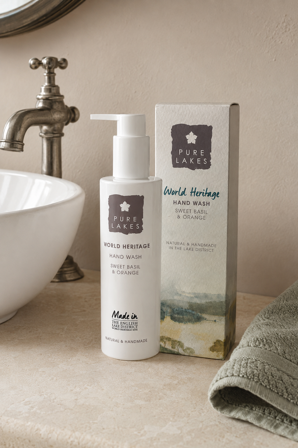 Pure Lakes World Heritage Sweet Basil & Orange hand wash bottle and its packaging box on a bathroom counter next to a sink and towel.