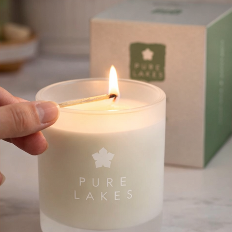 Pure Lakes candles being lit with match in front of packaging 