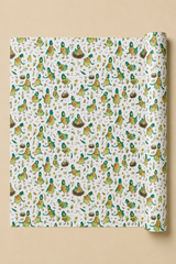A roll of wrapping paper with a dense pattern of illustrated birds in green, yellow, and brown on an off-white background, shown against a solid beige backdrop.