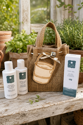 A mini hessian tote bag with a wooden bucket tag which can be personalised sits on a wooden surface outdoors with Pure Lake products Foot Gel, Anti-insect lotion and after sun lotion.