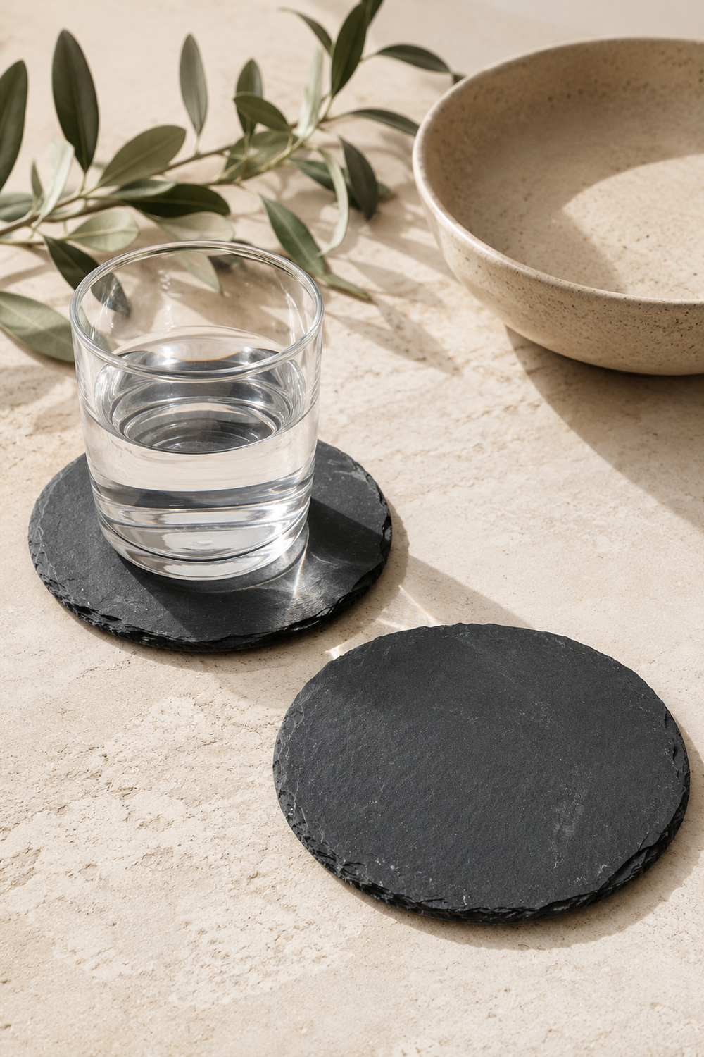 Set of 2 round slate drinks coasters made from natural slate with rustic edges.