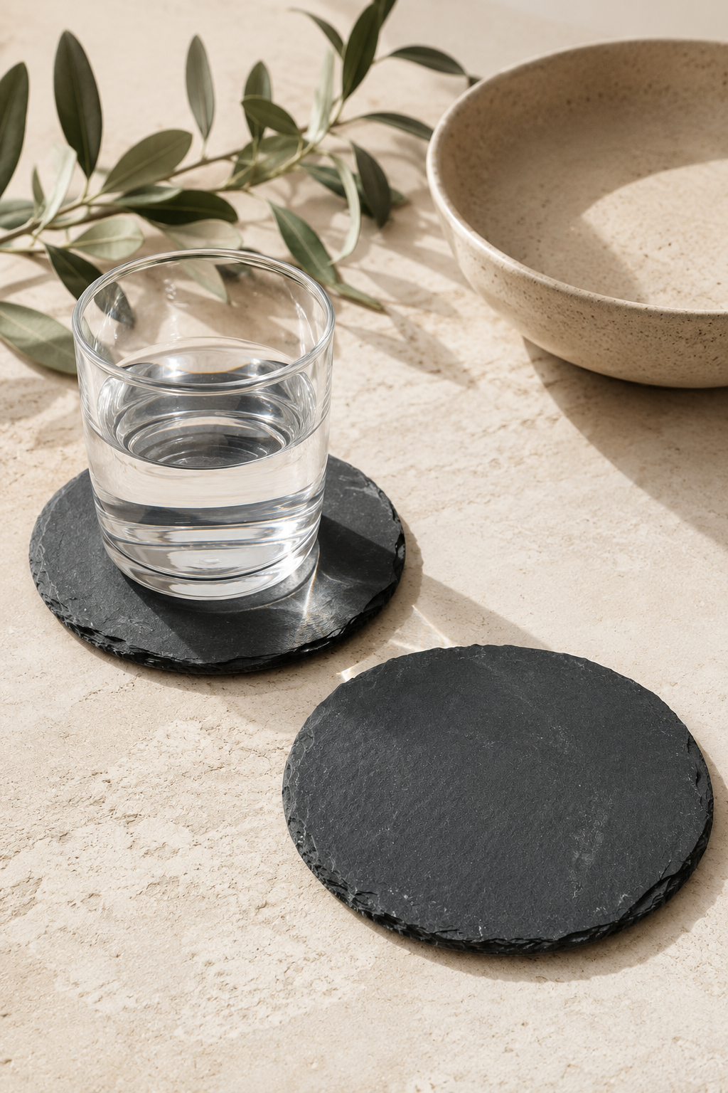 Set of 2 round slate drinks coasters made from natural slate with rustic edges.