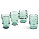 Set of four green glass tumblers with textured design that makes a fish when stacked on a white background