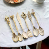 Set of ornate gold cutlery on a marble surface