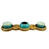 Three teal ceramic bowls on a wooden tray with a white background