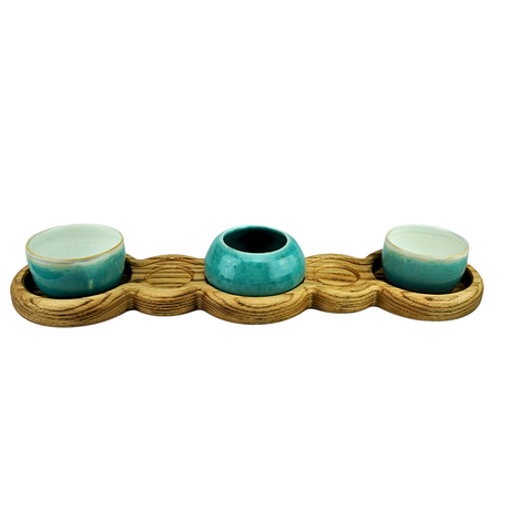 Three teal ceramic bowls on a wooden tray with a white background