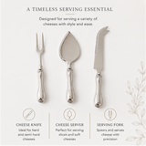 Silver cheese knife, server, and fork set on a wooden board with cheese and grapes.
