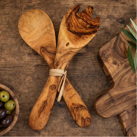 Set of wooden salad servers with olive design on a rustic background