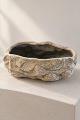 Empty rock effect ceramic plant pot showing its irregular rim and mottled grey and cream texture