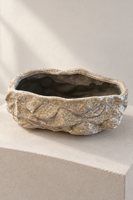 Empty rock effect ceramic plant pot showing its irregular rim and mottled grey and cream texture