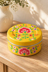 Gift set containing five hand-poured beeswax-blend candles in handmade terracotta pots and one reusable yellow stainless steel tin. The round tin is hand-painted in Kashmir with multicoloured floral decoration.