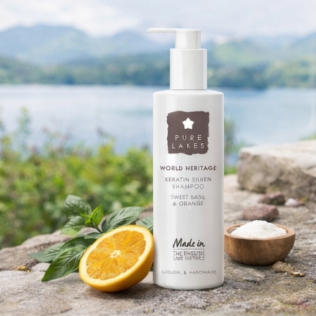 Pure Life Naturals products with a bottle, oranges, Sweet Basil & Orange Keratin Silken Shampoo