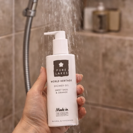 Pure Lake world heritage shower gel with a hand holding a bottle, in a bathroom setting