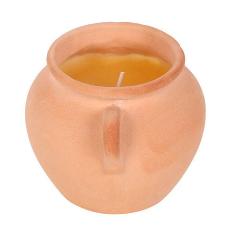 Terracotta pot with a candle inside on a white background