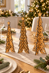 Three laser-cut wooden Christmas tree centerpieces with star toppers, displayed on a decorated dining table runner in a festive holiday setting.