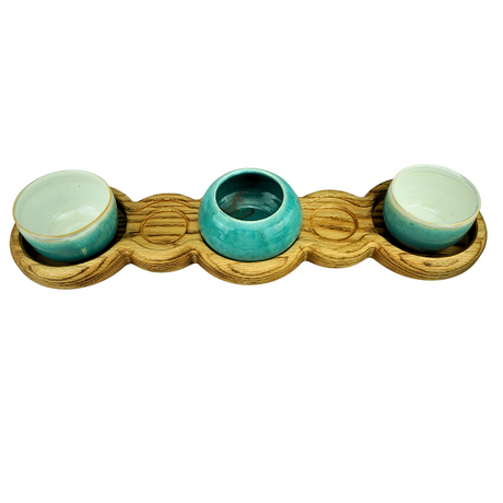 Three teal ceramic bowls on a wooden tray with a white background