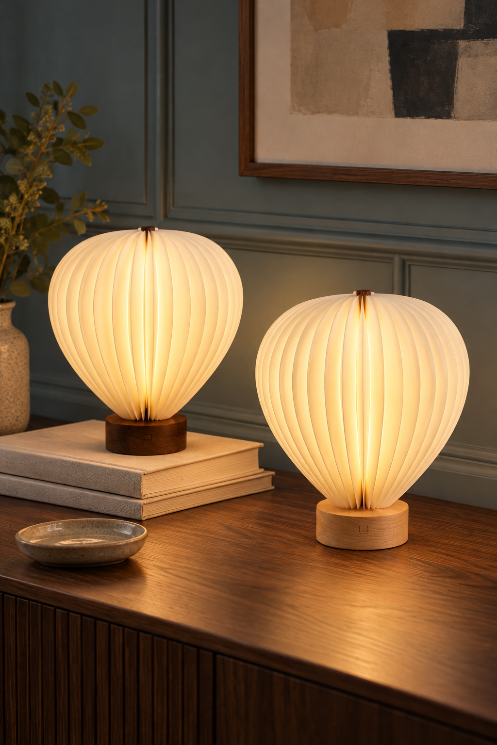 Aeris hot air balloon lamps in natural walnut and beech wood displayed side by side on a pale stone surface