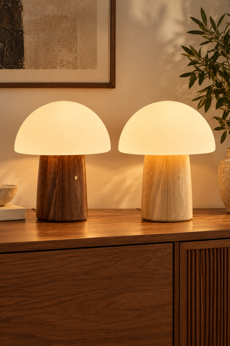 Large Alice Mushroom Lamps in walnut and white ash glowing warm white side by side on a wooden sideboard.