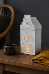 White Nordic house wax warmer displayed on a cosy mantelpiece with warm neutral home accessories.