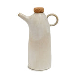 White ceramic oil dispenser with cork lid on a white background