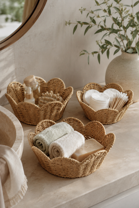 Wicker baskets on a bathroom counter with towels, soap, and other items.