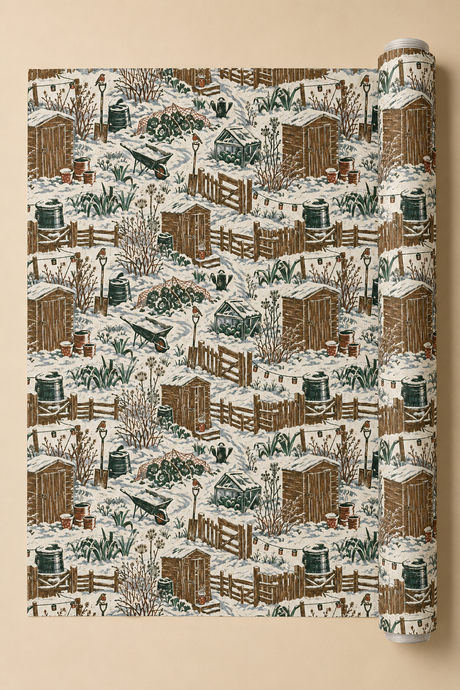 Winter allotment Christmas wrapping paper showing snow-covered sheds, fences, cold frames, cabbages, wheelbarrows, garden tools and robins in deep green and brown.