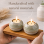 Set of ceramic candle holders on a wooden stand with candles, emphasizing a cozy atmosphere.