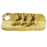 Wooden Charcuterie board with engraved rabbits and a tag on a white background