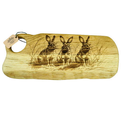 Wooden Charcuterie board with engraved rabbits and a tag on a white background