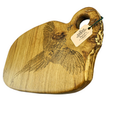 Wooden cutting board with engraved pheasant design and a tag on a white background