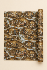 A roll of wrapping paper or wallpaper with a repeating illustrated pattern of badgers in cozy cottage scenes, shown partially unrolled on a light beige background.