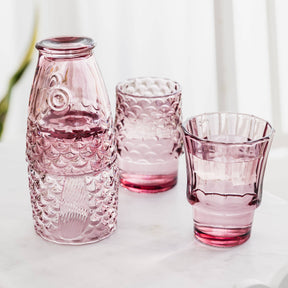 Set of 4 pink glass  and glasses on a white surface