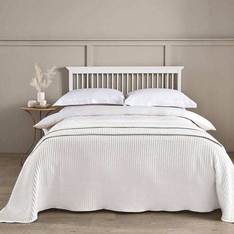Neatly made bed with white bedding in a bedroom setting