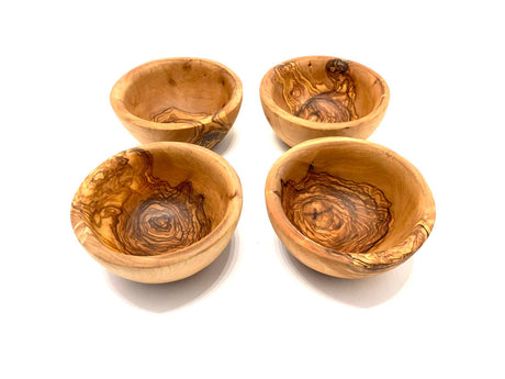 Four wooden tapas bowls with a natural, swirled pattern on a white background