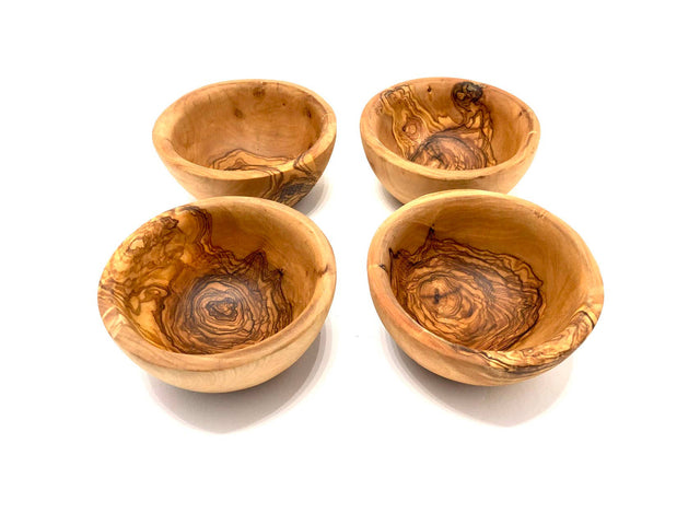 Four wooden tapas bowls with a natural, swirled pattern on a white background