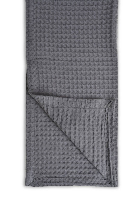 Grey textured blanket folded on a white background